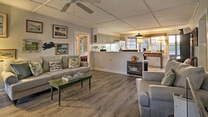 A spacious living area with a sofa, coffee table, and a ceiling fan. - Pawleys Island House, - Steps to Beach & Creek! (Pawleys Island)