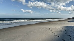 A beach with footprints in the sand and a clear sky with clouds. - Pawleys Island House, - Steps to Beach & Creek! (Pawleys Island)