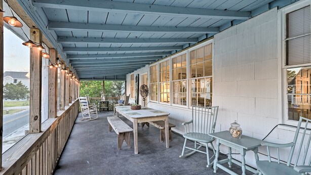 An outdoor covered patio with wooden benches, a table, and chairs. - Pawleys Island House, - Steps to Beach & Creek! (Pawleys Island)