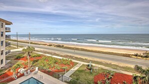 A beachfront hotel with a pool, a road leading to the beach, and a view of the ocean. - Oceanfront Ormond Beach Condo w/ Pool Access! (Ormond Beach)