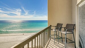 A balcony with a view of the beach and ocean.