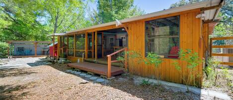 A wooden cabin with a covered porch and a small deck.