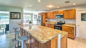 A modern kitchen with granite countertops, wooden cabinets, and stainless steel appliances. - Punta Gorda Escape w/ Private Lanai & Pool! (Punta Gorda)