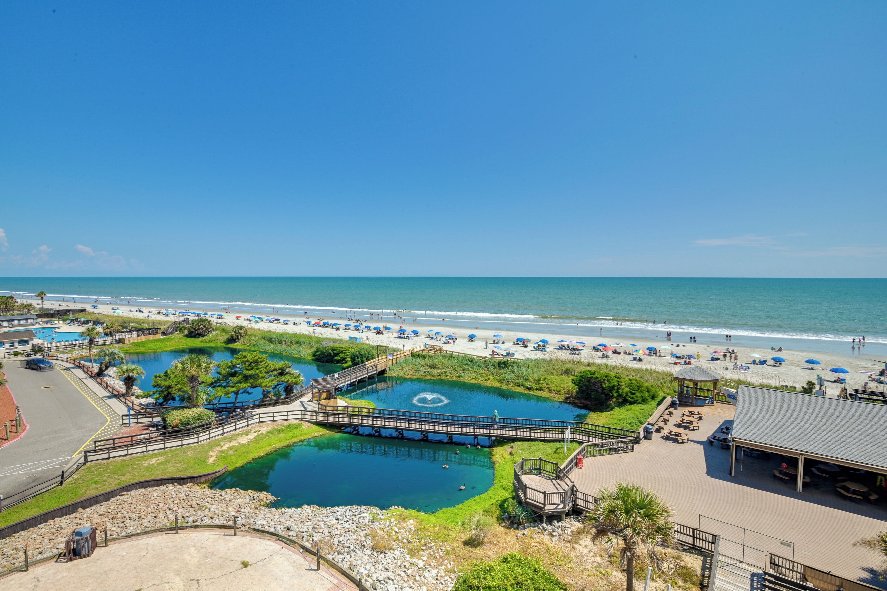Ein Strandresort mit Schwimmbad, Strandbädern und einem Pavillon.