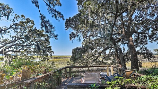A wooden deck with a bench and a hammock, surrounded by trees and marshland. - Rustic Beaufort Home w/ Stunning Marsh Views! (Beaufort)