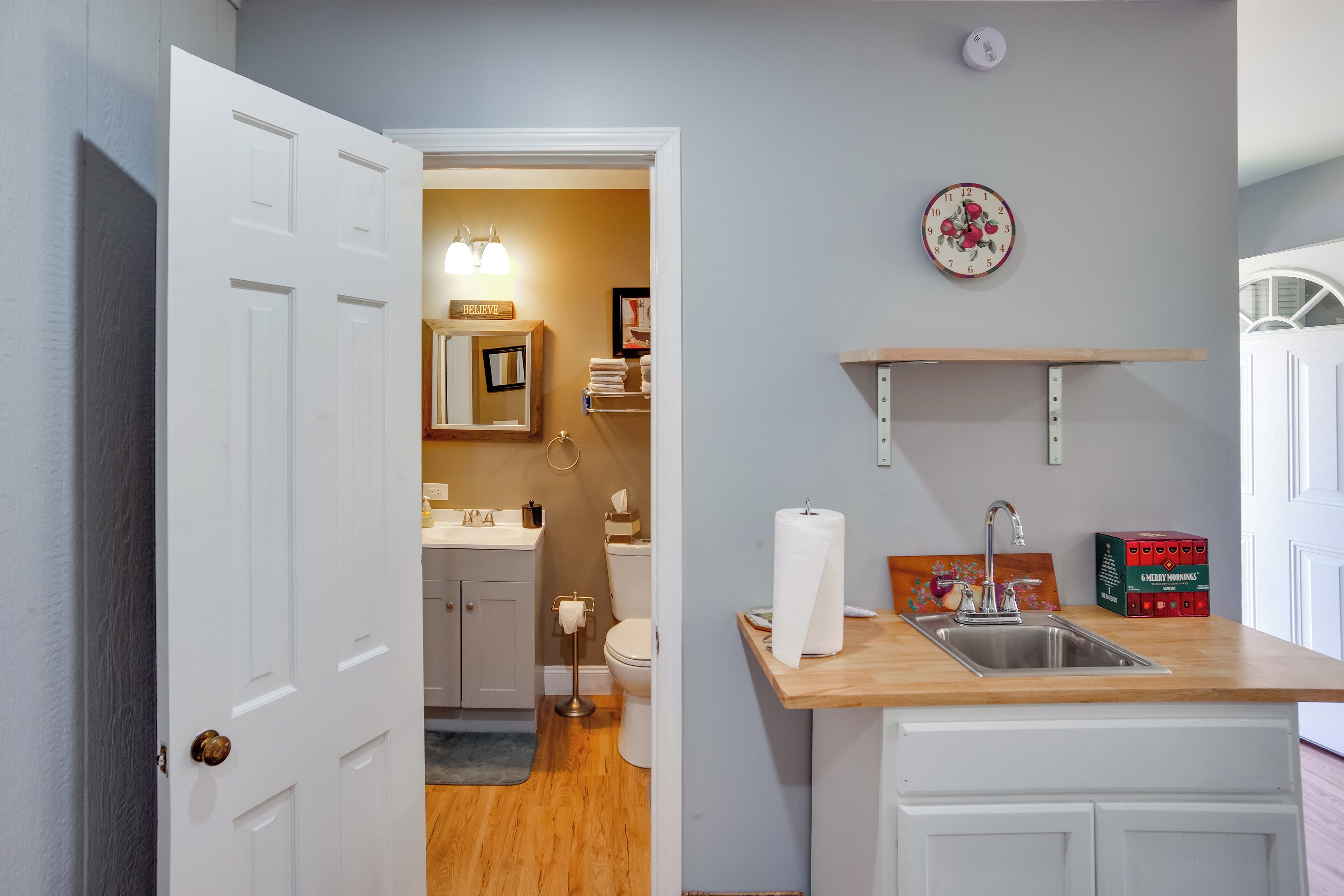 Una cocina con mostrador de madera, un lavabo y un estante en la pared.
