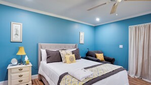 A bedroom with a large bed, a bedside table, a ceiling fan, and a window with curtains. - Saint Helena Island Getaway w/ Marsh Views! (Saint Helena Island)