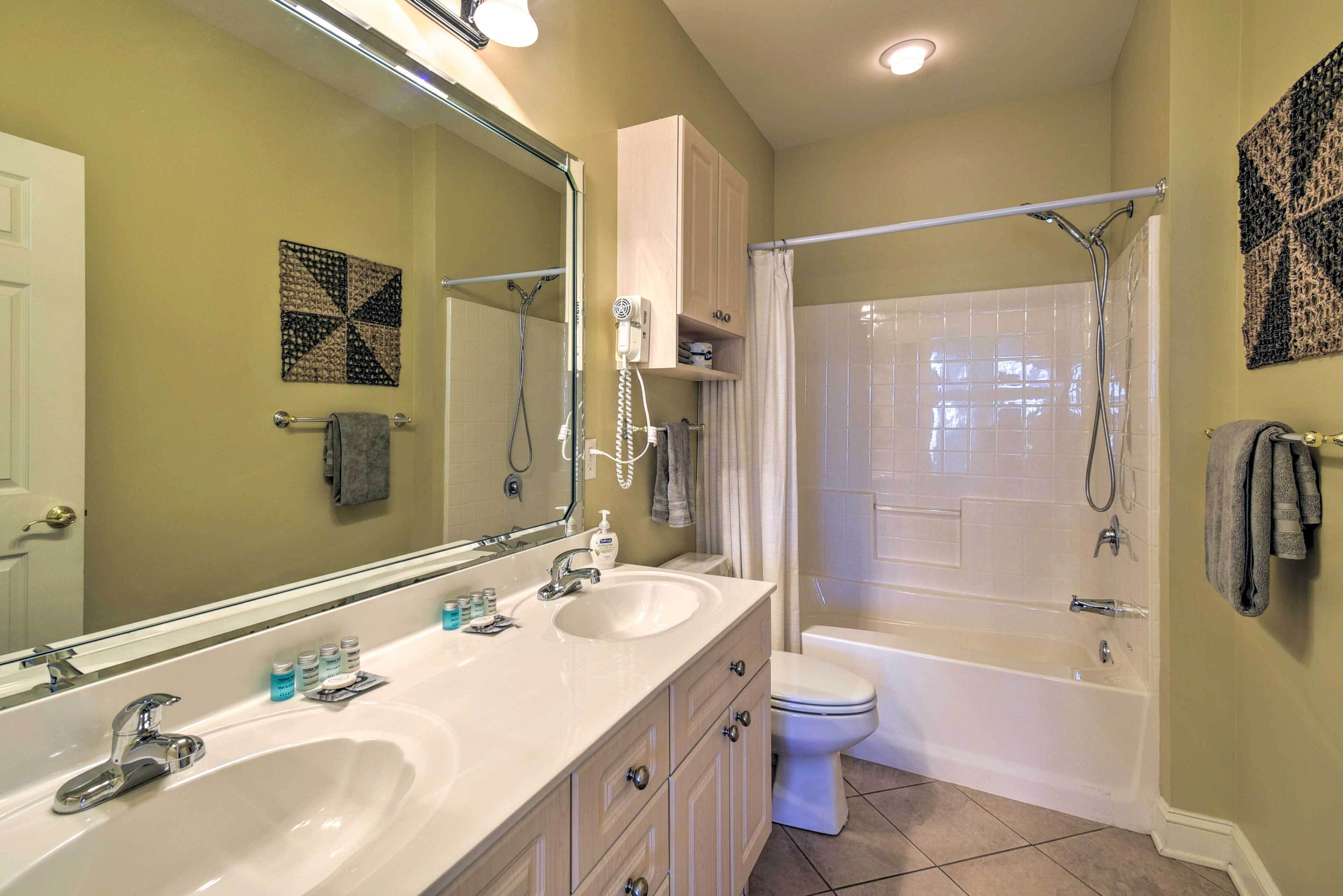 A bathroom with two sinks, a toilet, and a shower.