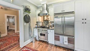 A kitchen with white cabinets, stainless steel appliances, and a red patterned rug. - Ridgeland Vacation Rental < 30 Mi to Beaufort (Ridgeland)