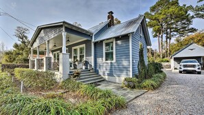 A two-story house with a covered porch, a chimney, and a gravel driveway. - Ridgeland Vacation Rental < 30 Mi to Beaufort (Ridgeland)