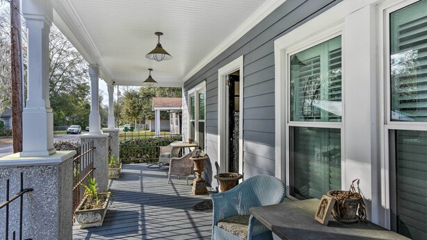 A covered porch with a table and chairs, potted plants, and a view of the street. - Ridgeland Vacation Rental < 30 Mi to Beaufort (Ridgeland)