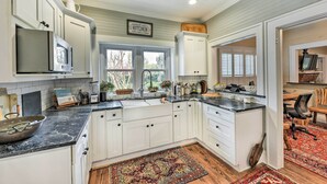 A spacious kitchen with white cabinets, a black countertop, and a ceiling fan. - Ridgeland Vacation Rental < 30 Mi to Beaufort (Ridgeland)