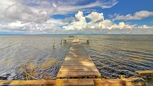 A wooden pier extending into calm water, with a bench at the end. - Santa Rosa Beach Bungalow 5 Mi to the Gulf Shore! (Santa Rosa Beach)