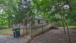 A wooden deck leading to a cabin with a small porch and a trash bin nearby. - Santa Rosa Beach Bungalow 5 Mi to the Gulf Shore! (Santa Rosa Beach)