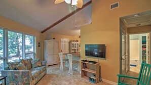 A living room with a sofa, chairs, a TV, and a bookshelf. - Santa Rosa Beach Bungalow 5 Mi to the Gulf Shore! (Santa Rosa Beach)