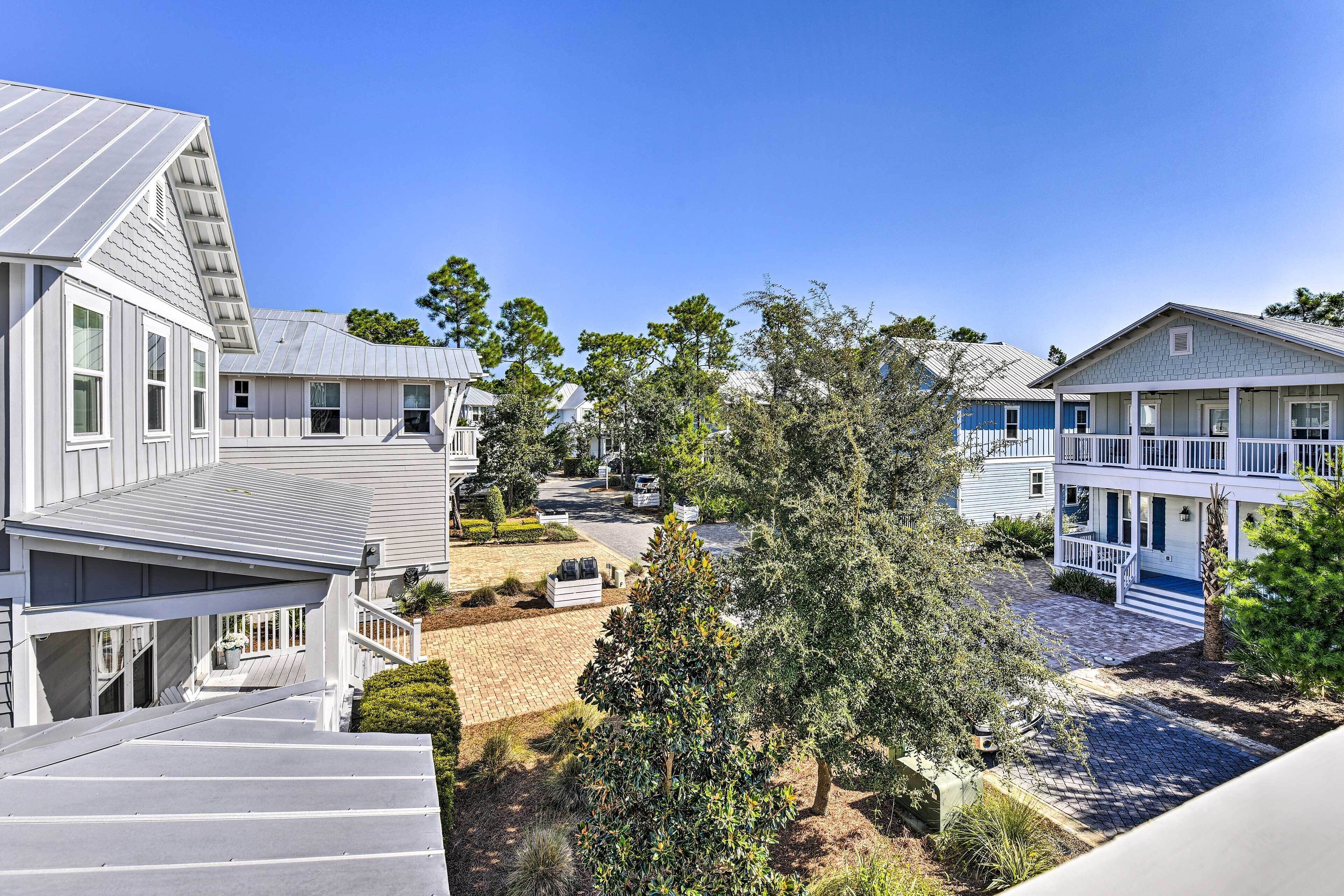 A residential area with multiple houses, a paved driveway, and a well-maintained lawn.