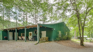 A rustic cabin with a covered porch, wooden furniture, and a wreath on the wall. - Pool & Fire Pit! 'outlaw Gameroom' in St Matthews (Saint Matthews)