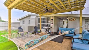 A covered patio with a hammock, outdoor furniture, and a grill area. - 'sarasota Sunset House' w/ Spacious Patio! (Sarasota)