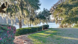 A park with a lake, trees with Spanish moss, and a grassy area with bushes. - Riverside Cottage: Close to Ocean and Myrtle Beach (Murrells Inlet)