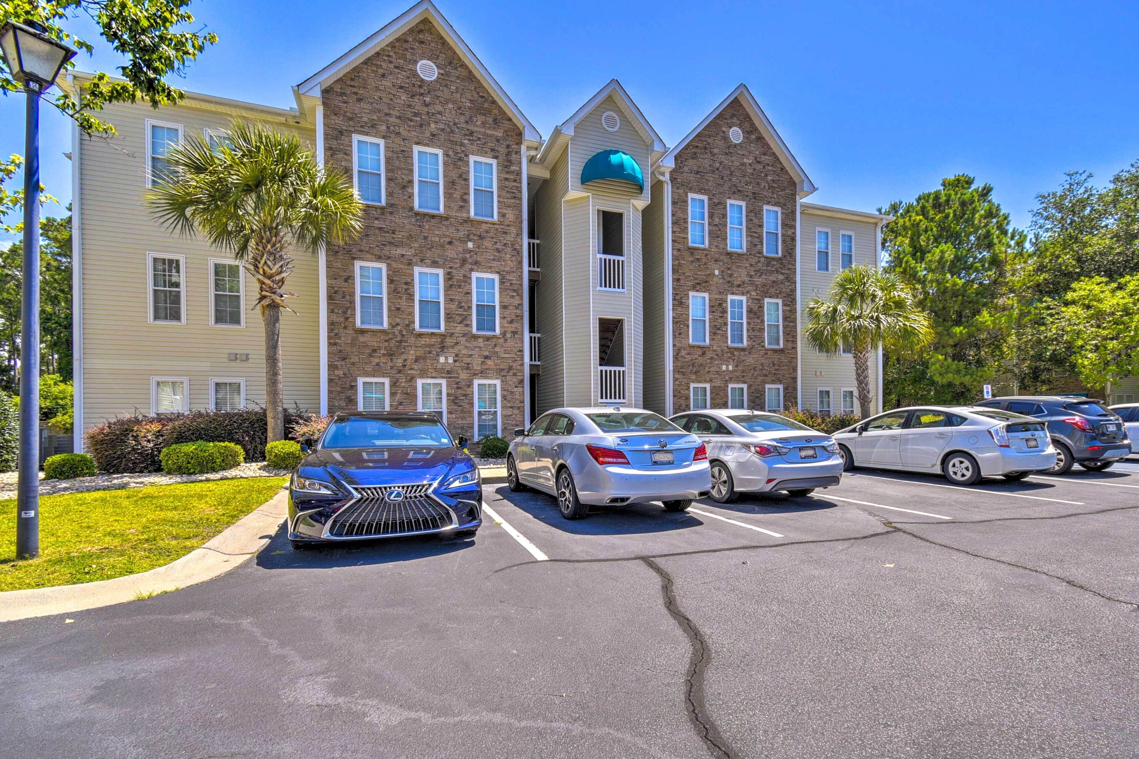 A multi-story building with a parking lot in front.