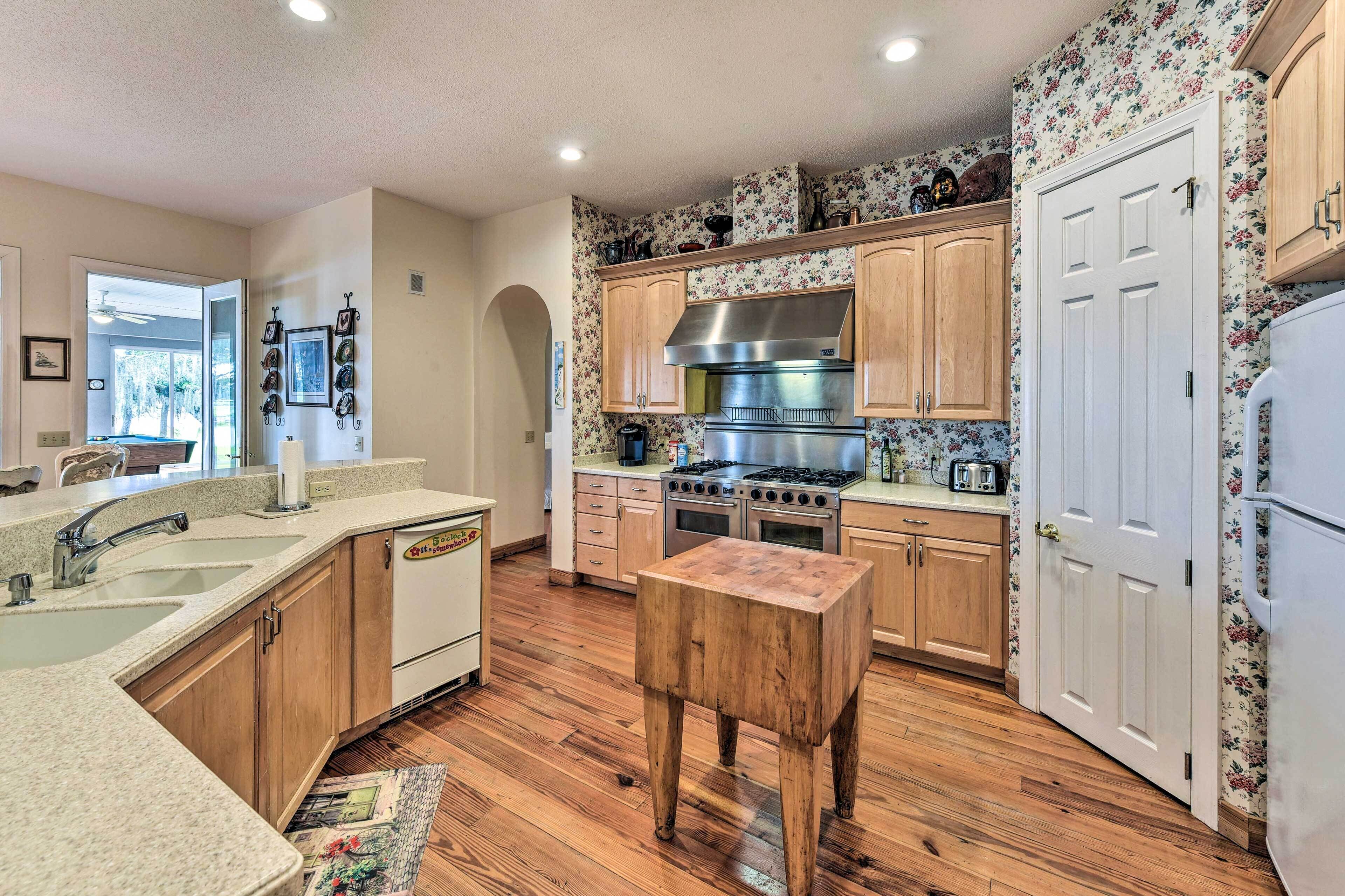 A kitchen with wooden cabinets, a stainless steel range hood, and a wooden stool.