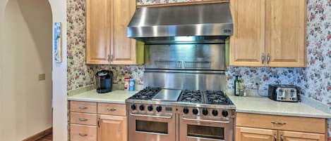 A kitchen with wooden cabinets, a stainless steel stove, and a toaster.