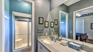 A bathroom with a shower, a sink, a mirror, and framed artwork on the wall. - Waterfront Home w/ Shared Dock on Okatie River (Bluffton)