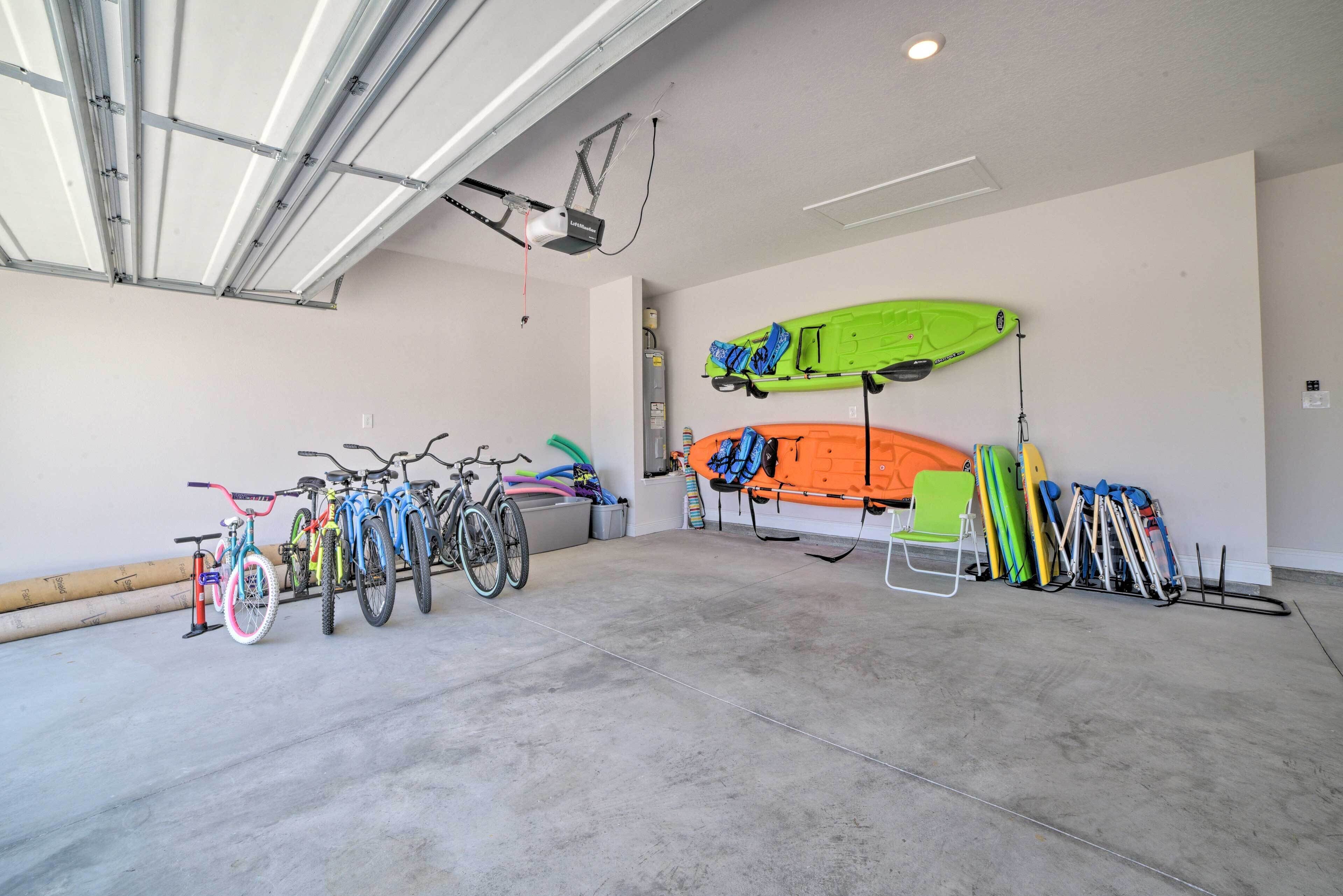 A garage with bicycles, kayaks, and a chair.