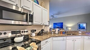 A modern kitchen with stainless steel appliances, white cabinetry, granite countertops, and a backsplash. - Spacious Clermont Getaway ~ 10 Miles to Disney! (Clermont)