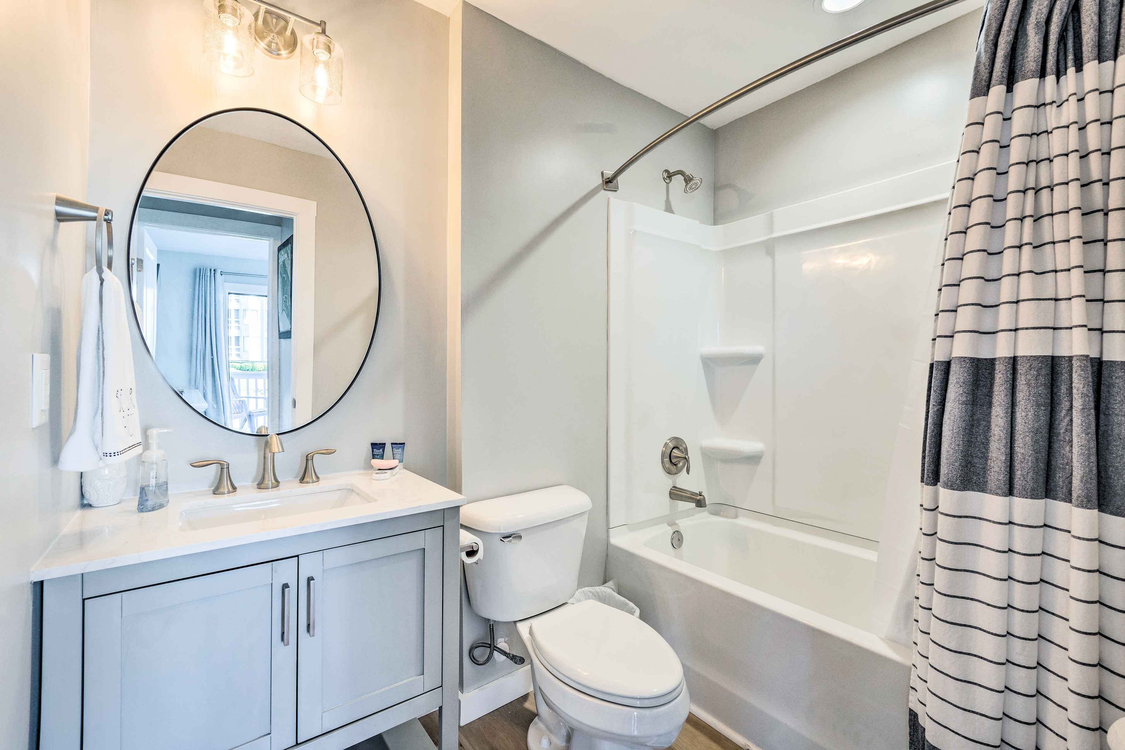 A modern bathroom with a white sink, toilet, and bathtub.