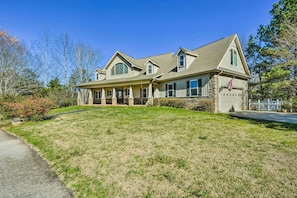 A two-story house with a stone foundation, a front porch, and a garage. - Spacious Seneca House ~ 7 Mi to Lake Keowee! (Seneca)