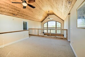 A spacious room with a sloped ceiling, a large window, and a balcony with a railing. - Spacious Seneca House ~ 7 Mi to Lake Keowee! (Seneca)