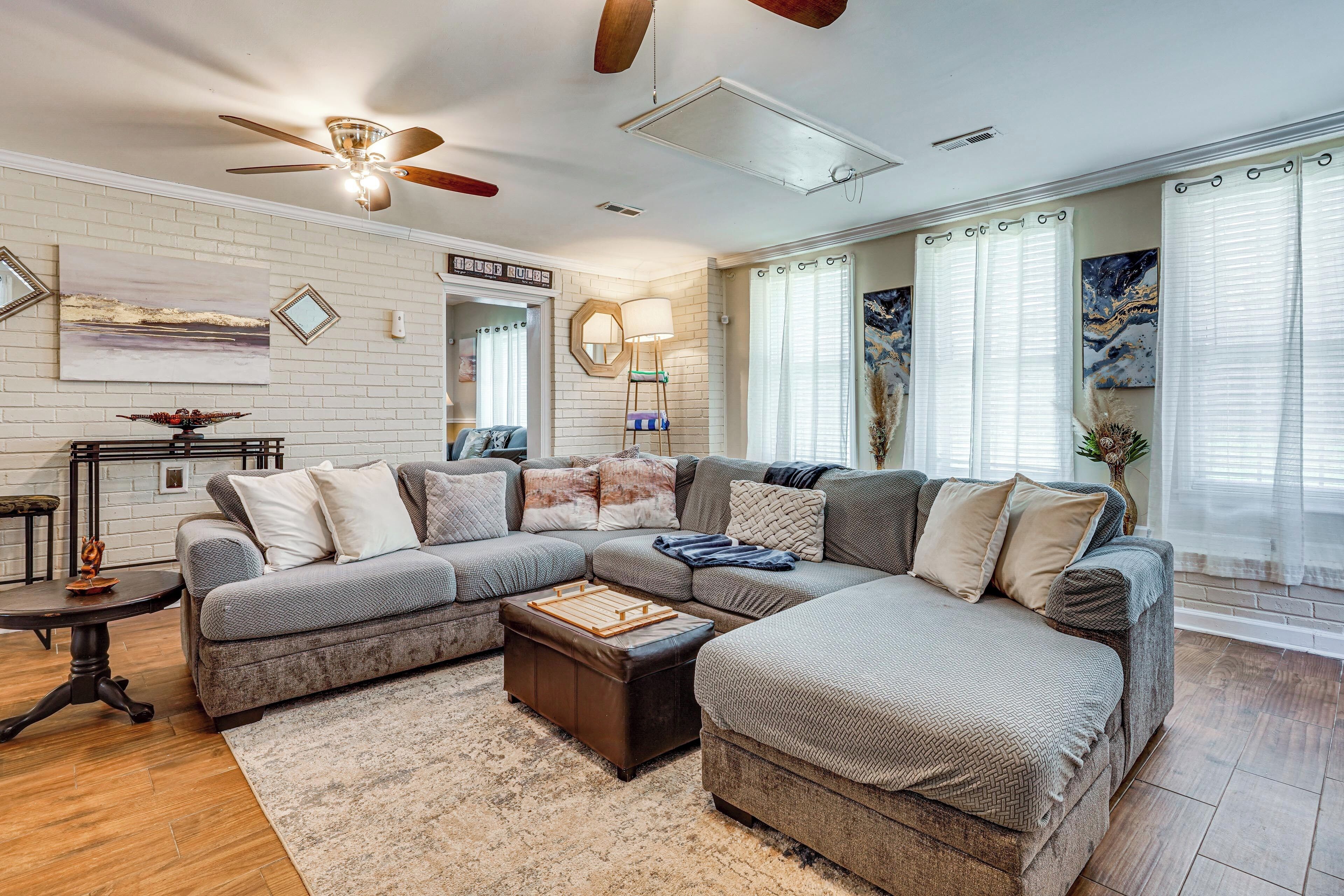 A living room with a sectional sofa, a coffee table, and a ceiling fan.