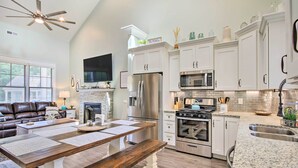 A modern kitchen with white cabinets, stainless steel appliances, and a granite countertop.