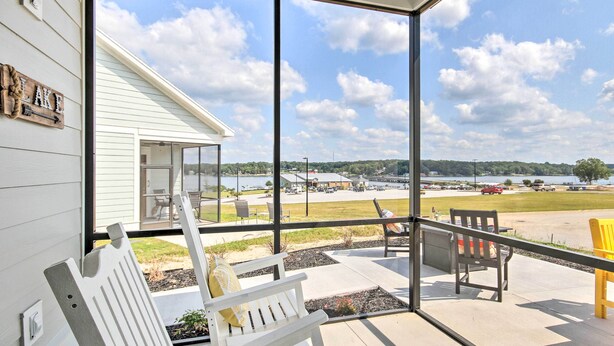 A covered patio with outdoor seating, a view of a parking lot and distant landscape.