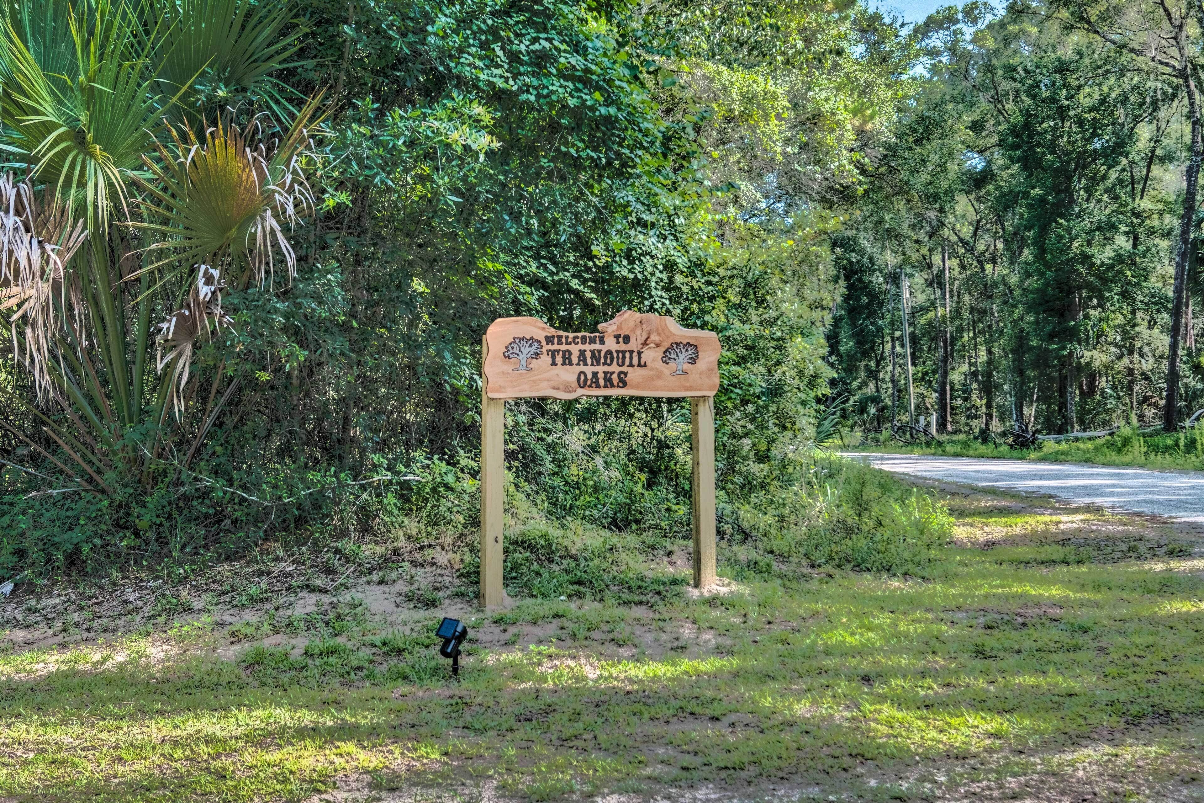 A wooden sign welcoming visitors to Tranquil Oaks.