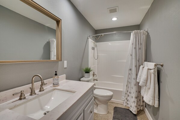 A bathroom with a sink, toilet, and shower.