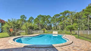 A swimming pool with a brick deck, surrounded by a fence and trees. - Stylish Bayfront Townhome < 10 Mi to Beach! (Mary Esther)