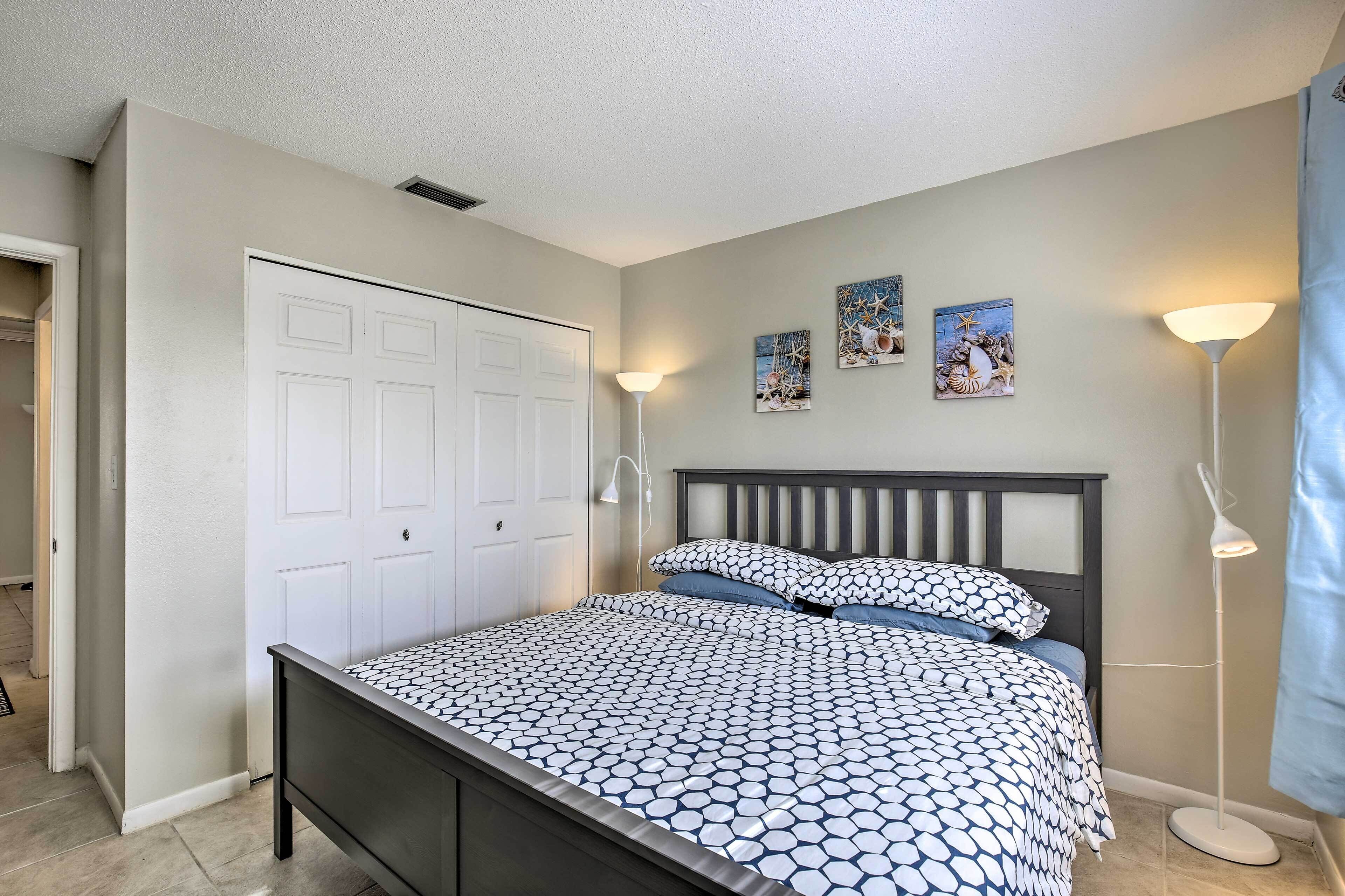 A bedroom with a bed, a wardrobe, and wall-mounted artwork.