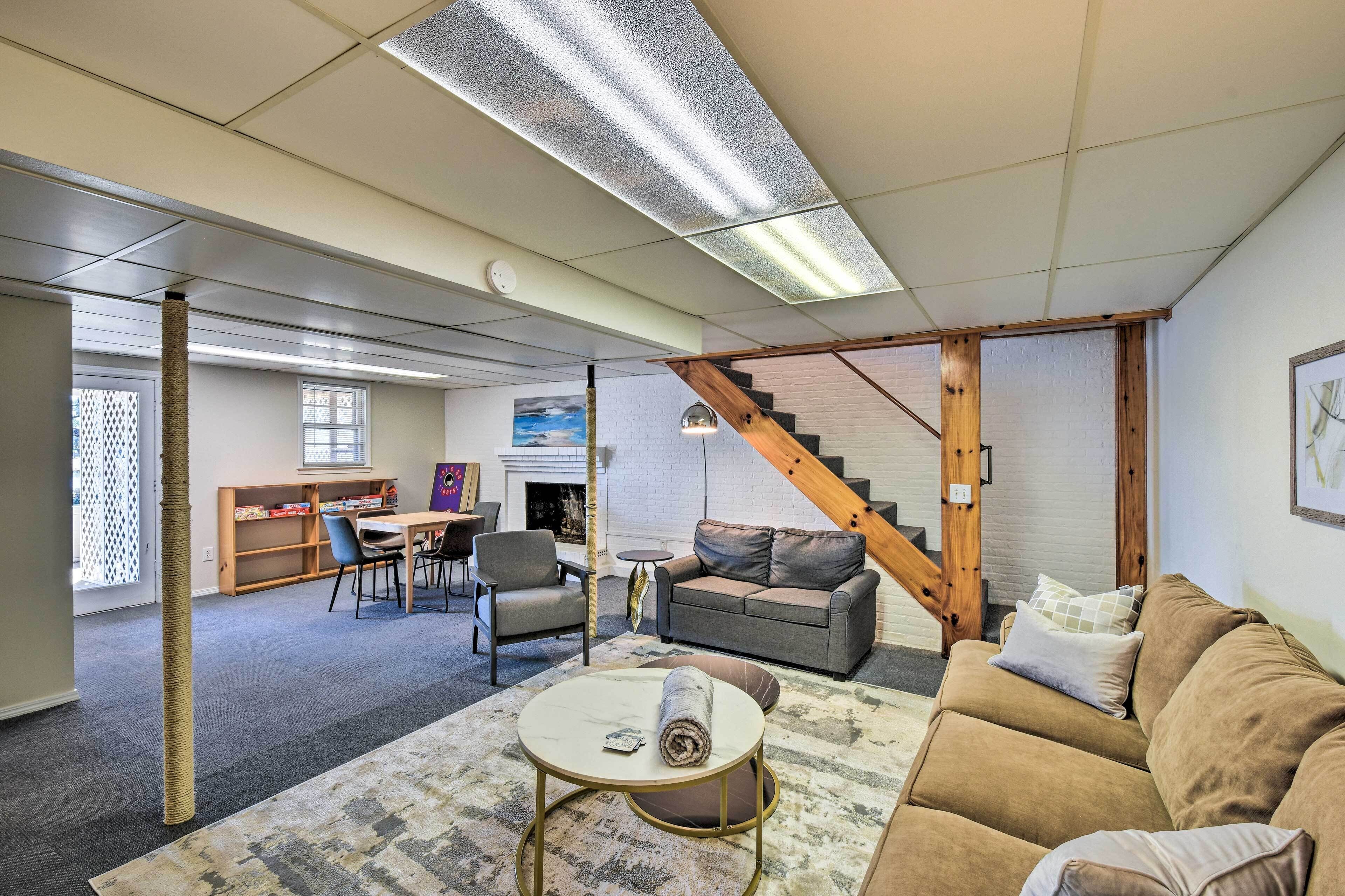A spacious living area with a sofa, a coffee table, a bookshelf, and a staircase.