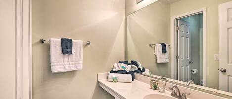 A bathroom with a sink, mirror, and towel rack.