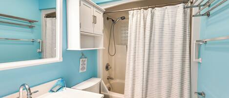 A bathroom with a bathtub, shower, toilet, and sink.