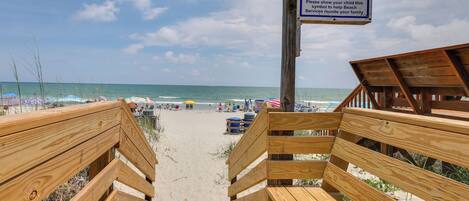 A wooden staircase leading to a beach with a sign for lost children.