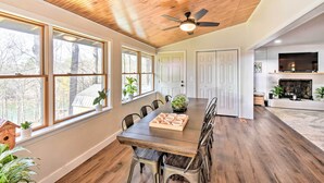 A spacious dining area with a wooden ceiling, large windows, and a fireplace. - Townville Lake House w/ Private Dock, Kayaks! (Townville)