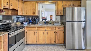 Eine Küche mit Holzschränken, Edelstahlgeräten und einer Arbeitsplatte aus Granit.