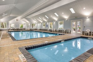 Una piscina interior con agua cristalina, bordes azulejados y múltiples carriles.