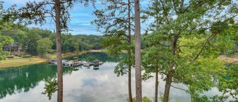 Un lac où l’on peut faire du bateau, entouré d’arbres, avec un bâtiment visible au loin.