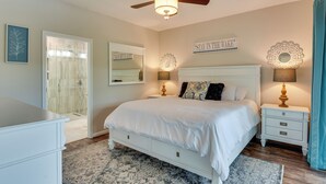 A bedroom with a bed, bedside tables, a ceiling fan, a shower, and a wall-mounted mirror. - Lake Keowee Resort Condo w/ Fantastic View (Salem)