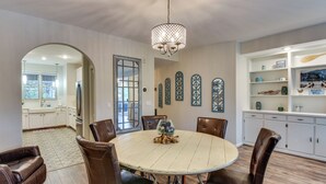A dining area with a round table, chairs, and a chandelier. - Lake Keowee Resort Condo w/ Fantastic View (Salem)