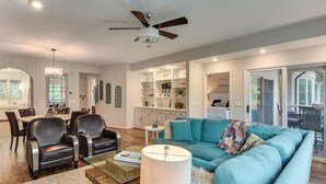 A modern living room with a blue sofa, leather chairs, a glass coffee table, and a ceiling fan. - Lake Keowee Resort Condo w/ Fantastic View (Salem)